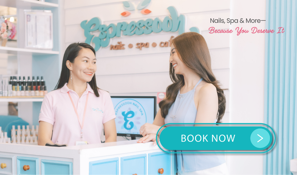 A smiling client at the Espressooh Nail Spa reception, engaging with a friendly staff member. The cozy, pastel blue interior and stylish decor create a relaxing ambiance. The text reads 'Nails, Spa & More—Because You Deserve It,' with a 'BOOK NOW' button